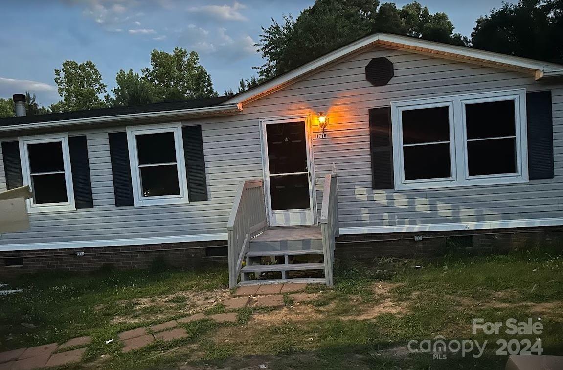 1770 Dark Corner Road Rutherfordton, NC 28139 - Photo 1 of 26 a backyard of a house with a large window and chairs