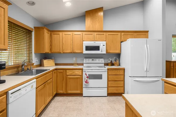 a kitchen with a sink a refrigerator and cabinets