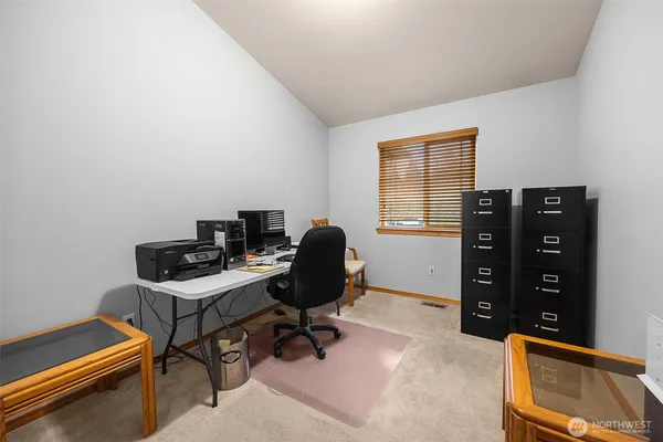 a view of a workspace with furniture and a window