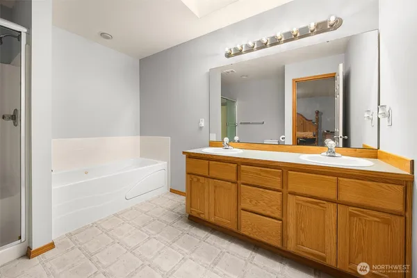 a bathroom with a tub sink and mirror