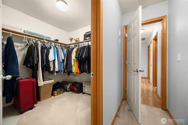a view of walk in closet with clothes and shoes