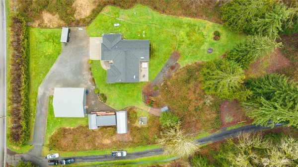 an aerial view of a house with a yard and street