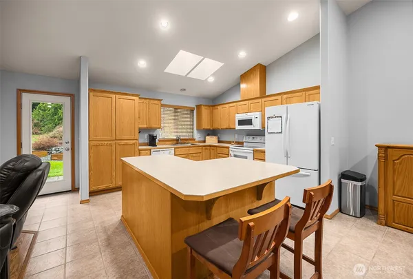 a kitchen with a table chairs refrigerator and a sink