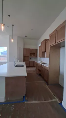 a kitchen with stainless steel appliances a refrigerator a sink dishwasher with a dining table and chairs