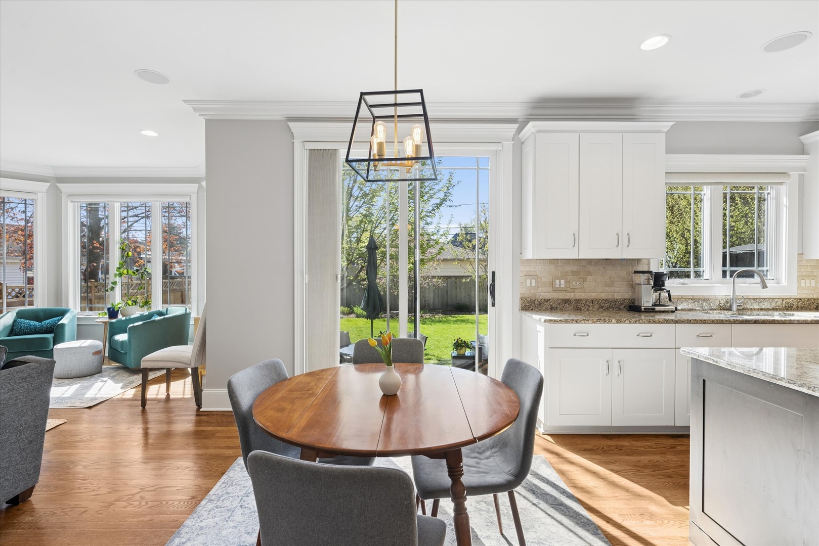 700 Swain Avenue Elmhurst, IL 60126 - Photo 13 of 33 a dining room with wooden floor a chandelier a glass table and chairs