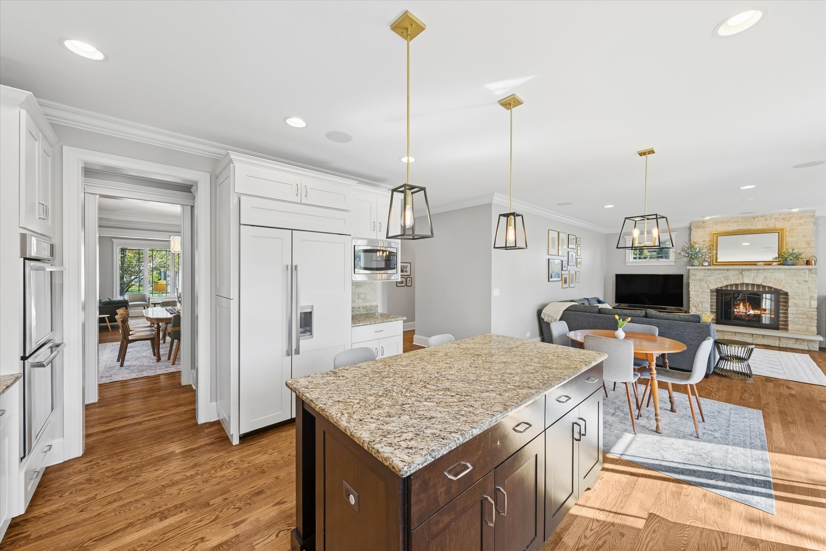700 Swain Avenue Elmhurst, IL 60126 - Photo 9 of 33 a kitchen with kitchen island stainless steel appliances granite countertop a stove top oven a refrigerator a sink and dining table with wooden floor