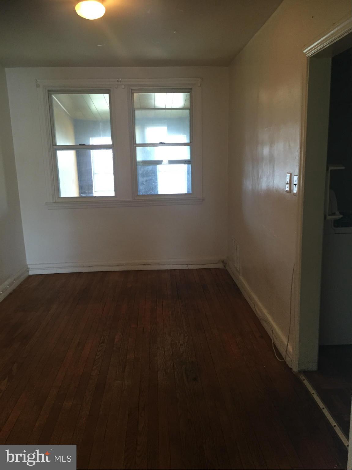 302 Old Riverside Road Baltimore, MD 21225 - Photo 3 of 10 an empty room with wooden floor and windows
