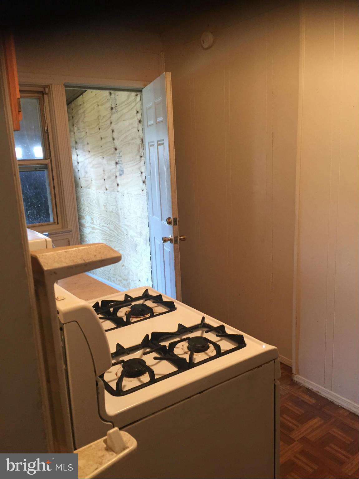 302 Old Riverside Road Baltimore, MD 21225 - Photo 4 of 10 a kitchen with a stove and a refrigerator