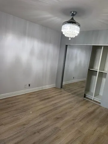 an empty room with wooden floor and mirror