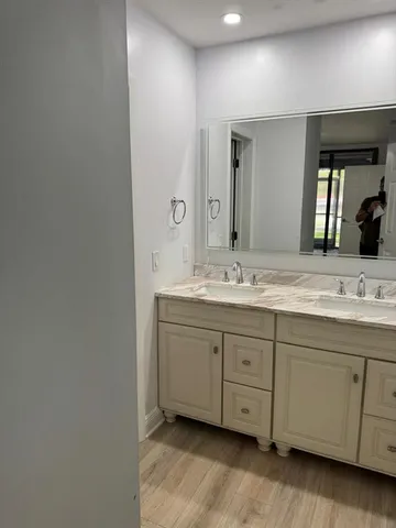 a bathroom with a double vanity sink and a mirror