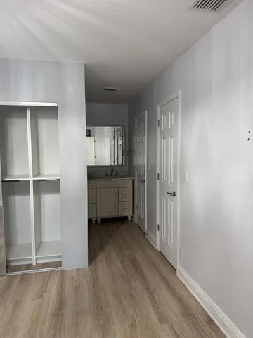 a view of a kitchen with wooden floor and cabinets