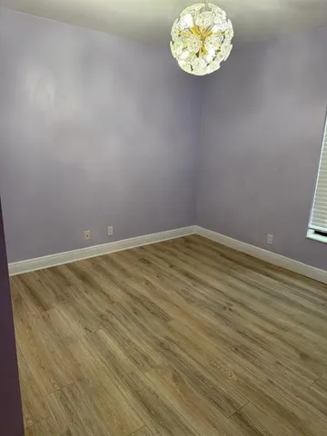 an empty room with a wooden floor and a window