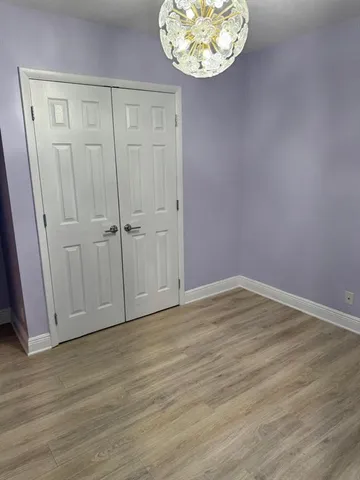 an empty room with wooden floor and cabinet