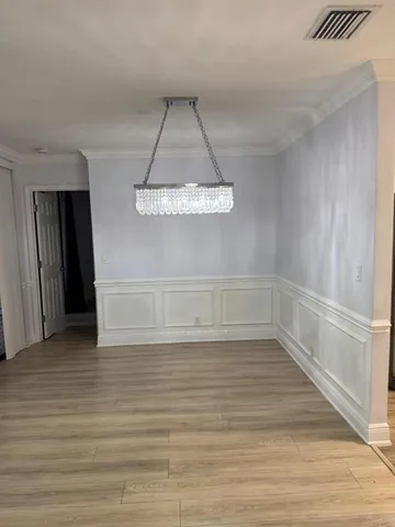 a view of a room with wooden floor and white walls