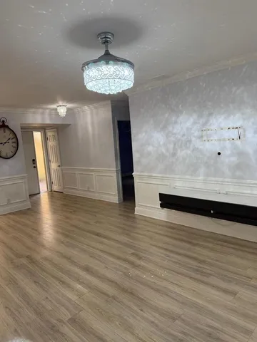 a view of a room with wooden floor and a hallway