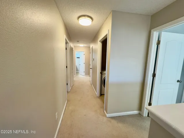 a view of a hallway with wooden shelves