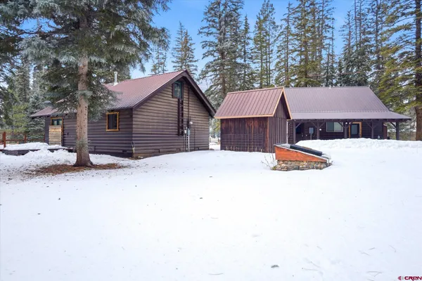 a view of a house with a yard covered in snow