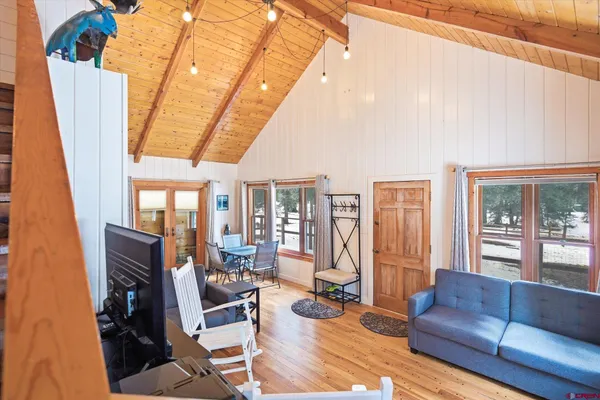 a living room with furniture a flat screen tv and a large window