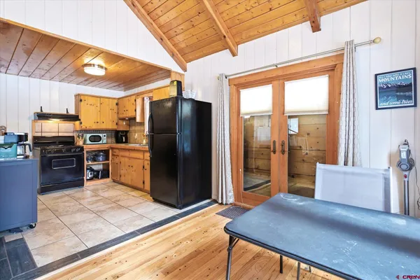a kitchen with stainless steel appliances wooden floor dining table and chairs