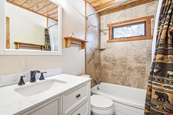 a bathroom with a granite countertop sink toilet and bathtub