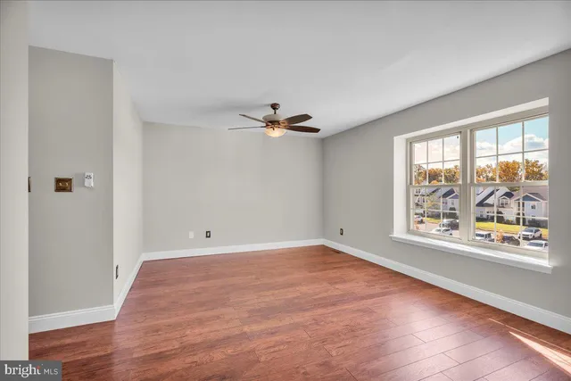wooden floor in an empty room with a window