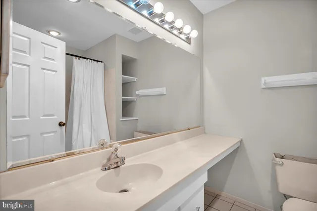 a bathroom with a sink a toilet and a mirror