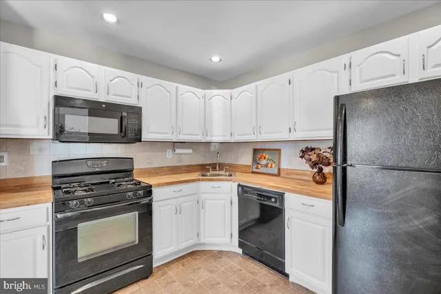 a kitchen with cabinets stainless steel appliances and a sink