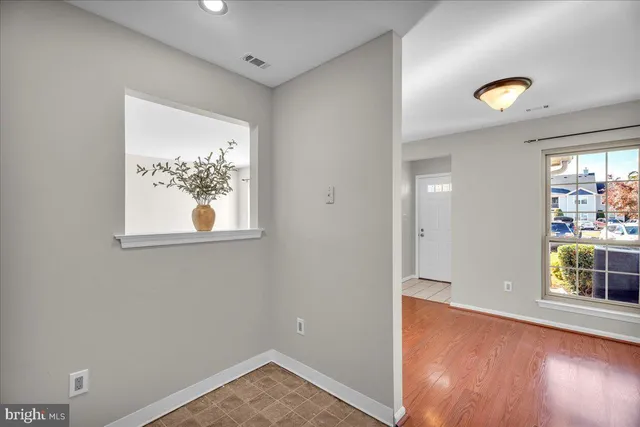 an empty room with window and wooden floor