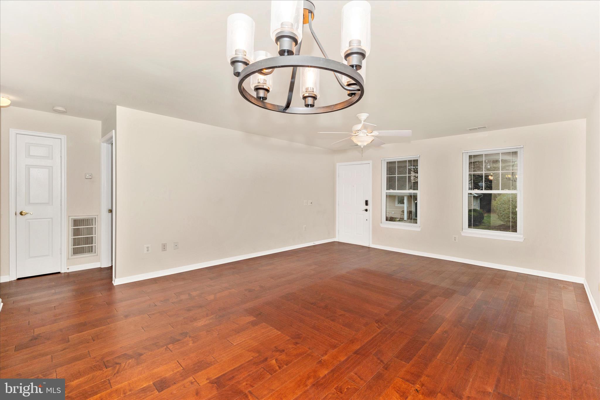 1110 Jousting Way Mount Airy, MD 21771 - Photo 14 of 56 an empty room with wooden floor chandelier fan and windows