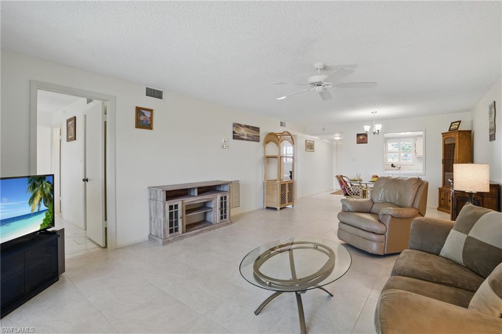 5435 Rattlesnake Hammock Road, Unit E202 Naples, FL 34113 - Photo 11 of 25 a living room with furniture a fireplace and a flat screen tv