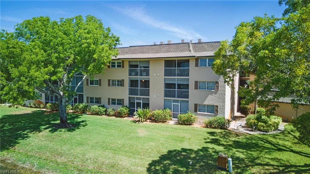 5435 Rattlesnake Hammock Road, Unit E202 Naples, FL 34113 - Photo 18 of 25 front view of a house with a yard