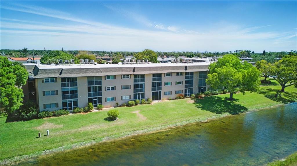 5435 Rattlesnake Hammock Road, Unit E202 Naples, FL 34113 - Photo 19 of 25 a view of a house with a yard and sitting area