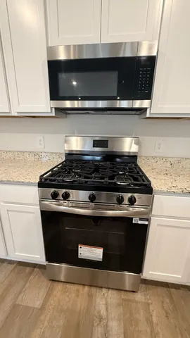 a stove top oven sitting inside of a kitchen