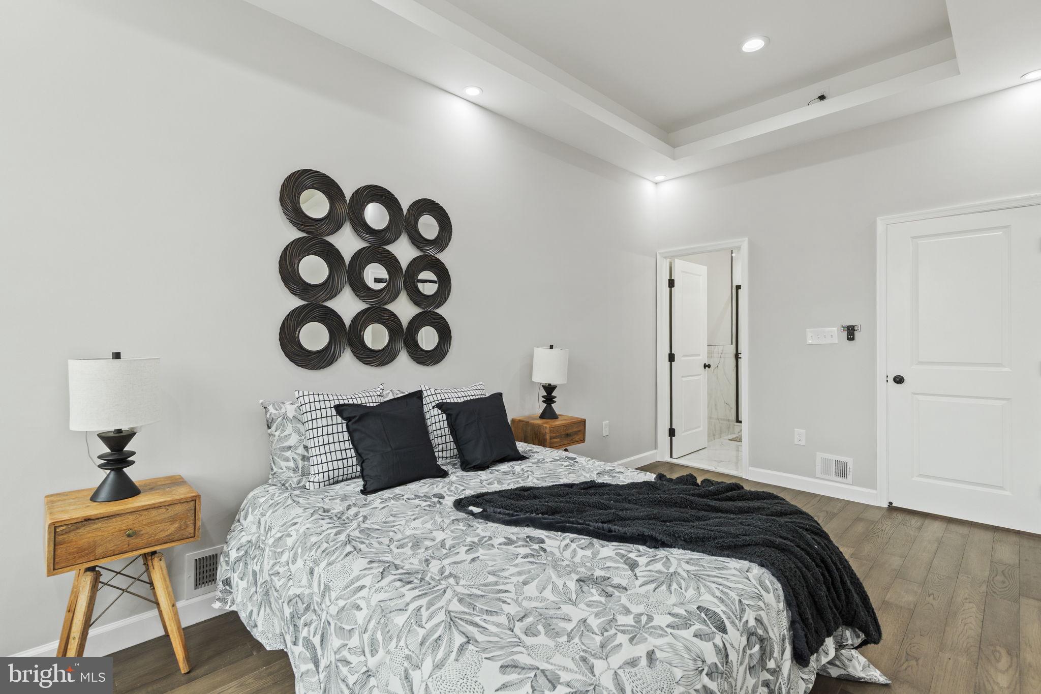 2245 East Preston Street Baltimore, MD 21213 - Photo 7 of 24 a bedroom with a bed and wooden floor