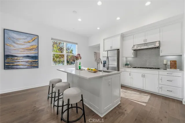 a kitchen with granite countertop white cabinets and stainless steel appliances