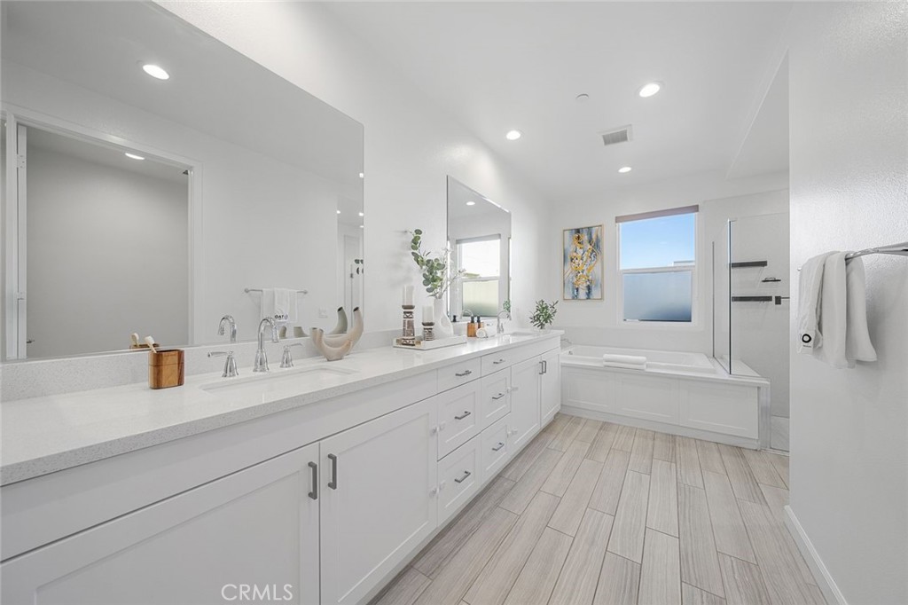 148 Follyhatch Irvine, CA 92618 - Photo 21 of 33 a bathroom with a double vanity sink a mirror and a bathtub