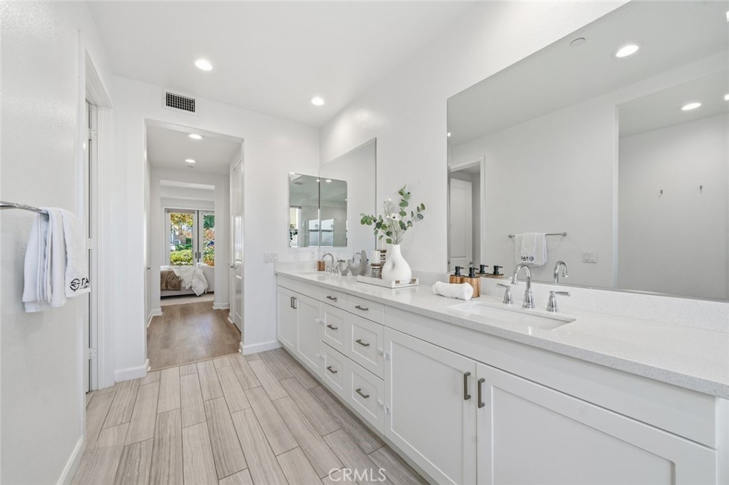 148 Follyhatch Irvine, CA 92618 - Photo 23 of 33 a spacious bathroom with a granite countertop sink and a mirror