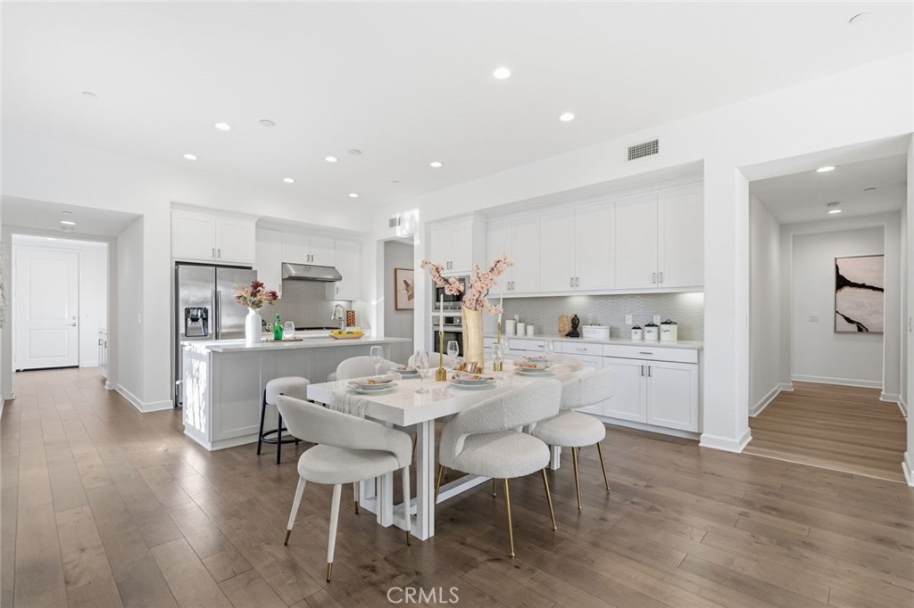 148 Follyhatch Irvine, CA 92618 - Photo 8 of 33 a kitchen with a dining table chairs refrigerator and cabinets