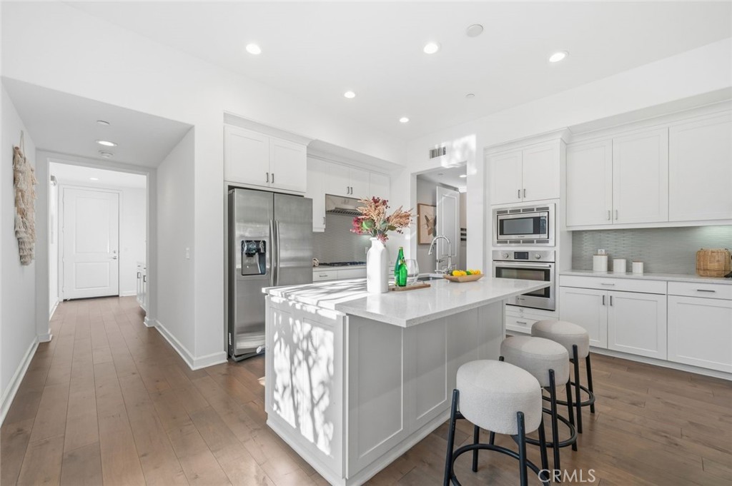 148 Follyhatch Irvine, CA 92618 - Photo 9 of 33 a kitchen with stainless steel appliances kitchen island granite countertop a refrigerator and a stove top oven