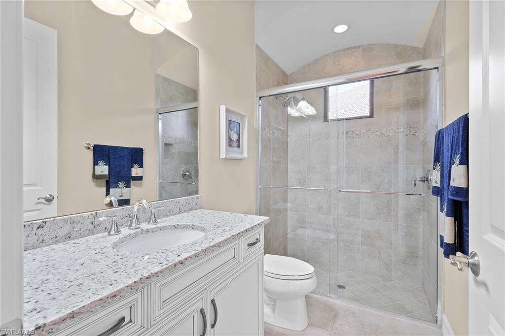 7440 Byrons Way Naples, FL 34113 - Photo 22 of 43 a bathroom with a granite countertop sink a toilet and shower