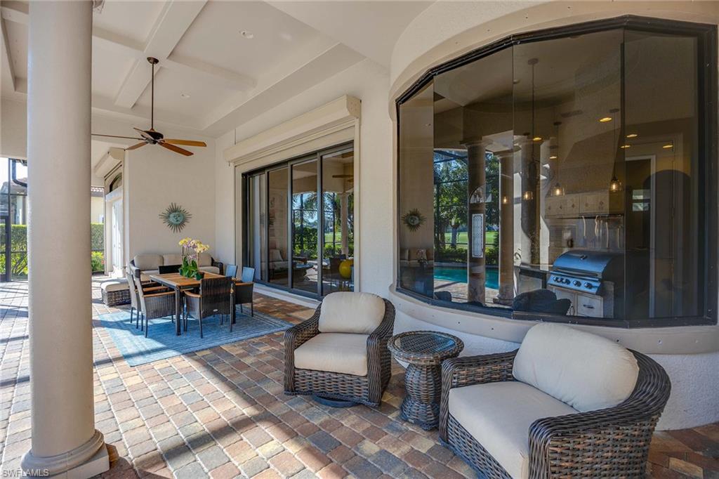 7440 Byrons Way Naples, FL 34113 - Photo 29 of 43 a living room with furniture a lamp and a chandelier