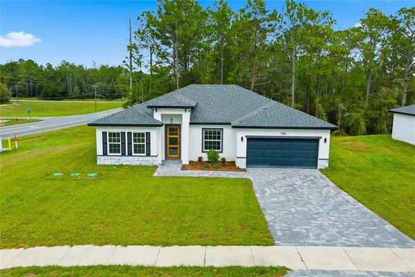 a aerial view of a house with swimming pool next to a big yard