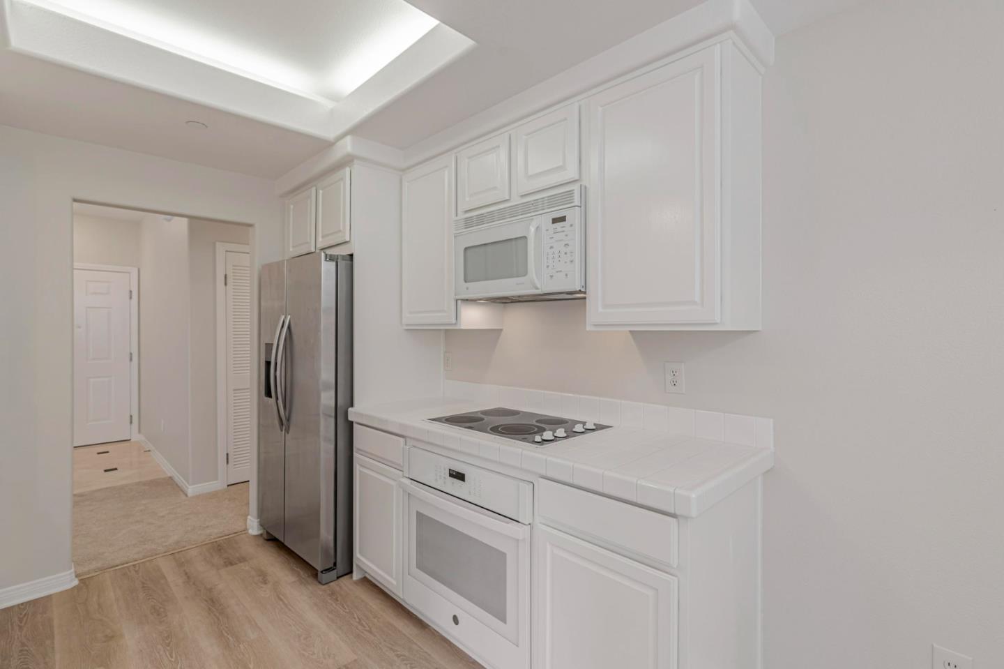 144 South 3rd Street, Unit 433 San Jose, CA 95112 - Photo 23 of 66 a kitchen with white cabinets and stainless steel appliances