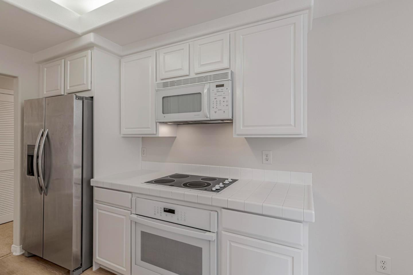 144 South 3rd Street, Unit 433 San Jose, CA 95112 - Photo 25 of 66 a kitchen with white cabinets and stainless steel appliances