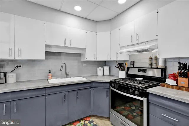 a kitchen with stainless steel appliances granite countertop a sink stove and cabinets