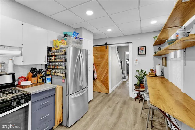 a kitchen with stainless steel appliances granite countertop a refrigerator and a stove top oven