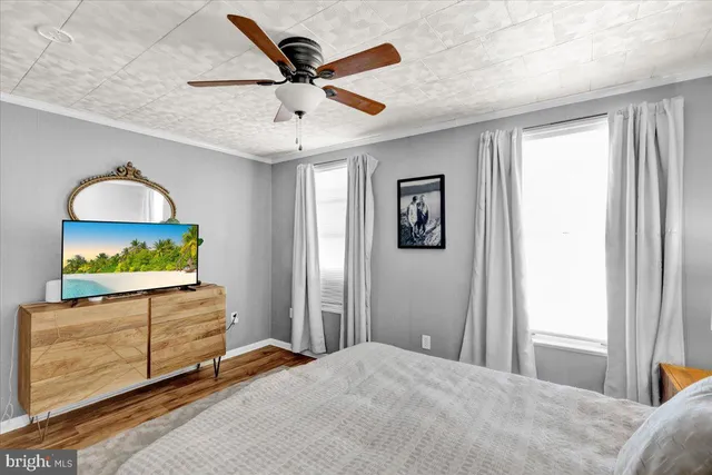 a bedroom with a bed and a dresser next to a window