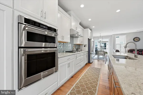 a kitchen with stainless steel appliances kitchen island granite countertop a stove top oven and sink