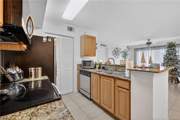 a kitchen with kitchen island granite countertop a sink stove and cabinets