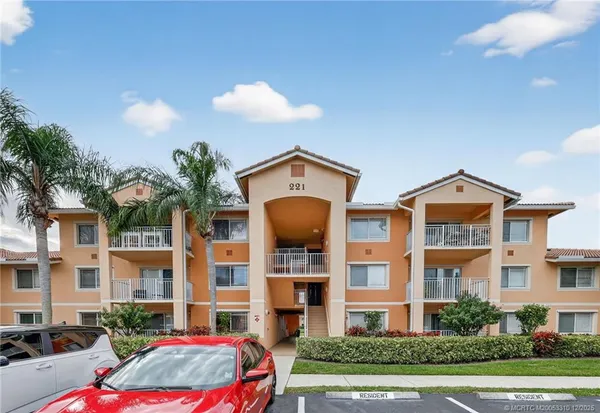 a front view of a residential apartment building with a yard and entryway